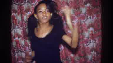 Bronx New York USA (1975): Young Black Girl Dancing In Front Of A Flowery Curtain
