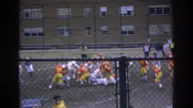 Bronx New York USA (1975): People Sitting By Chain Link Fence Watching A Football