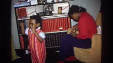 Washington DC USA (1975): Two Children Playfully Rough House While Mom Works With