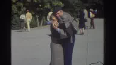 Greece (1976): Elderly Couple Dances On Park Sidewalk , Old Brick Church Entrance