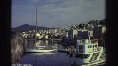 Greece (1976): Ships At Anchor In A Harbor Populated With Homes That Climb Up A