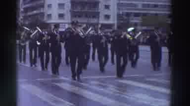 Greece (1976): Bands In Uniform March Down An Urban Street Wet With Moisture As