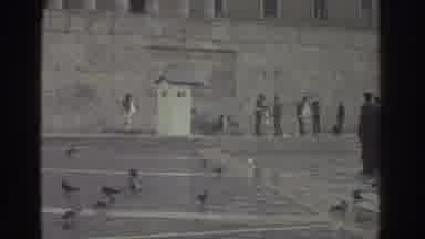 Greece (1976): People Are Outside Doing What Looks Like A Military March
