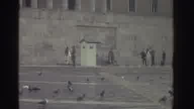 Greece (1976): A Soldier Hands A Wreath To A Civilian Dressed In A Suit To Place