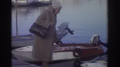 GREECE-1976: People In Coats By Water With Motorboat And Fortress