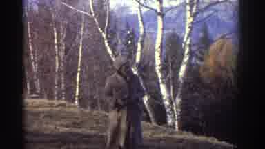 Greece (1976): Cloaked Woman Walking On Grassy Hill Snowy Mountains In Background