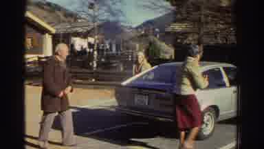 Greece (1976): Three Older Adults Getting Into Car In Hilly Urban Area