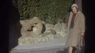 Greece (1976): A Woman Stands On The Street In Front Of A Rock Wall And Then Turns