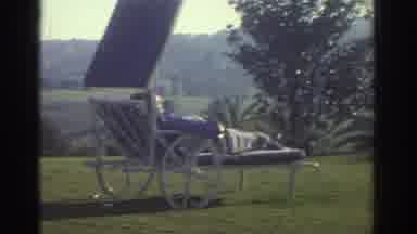 Greece (1976): A Person Is Laying On A Lawn Chair Wearing A Red Jacket