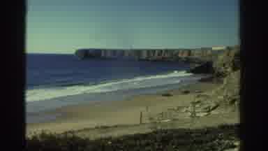 Greece (1976): Ocean Shore And Crashing Waves In Front Of A Cliff, Man Approaches