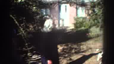 Greece (1976): A Mother Helps Her Daughter Climb A Small Tree In The Yard While