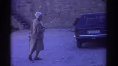 Greece (1976): Woman Wearing A Coat Is Walking Up To A Giant Castle Next To Car