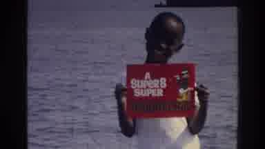 Harlem New York USA (1976): Boy Holds Up Sign Reading, "Super 8"; Two Boy Approach