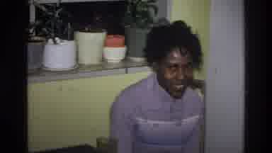 Harlem New York USA (1976): Woman Sitting At A Table Smiling During Social
