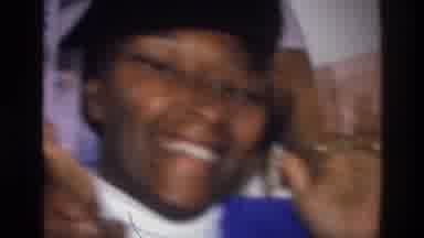 Harlem New York USA (1976): Woman Wearing Black Hat, Blue Sweater Holds Hands Up
