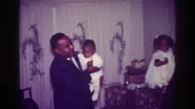 Harlem New York USA (1976): Two African American Men Hold Small Children Dressed