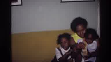 Harlem New York USA (1976): A Woman Holds Her Two Daughters As She Points To The