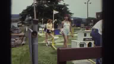 Watkins Glen New York USA-1976: Three Teens Playing Miniature Golf, White Boat