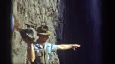 California USA (1937): Man Throwing A Giant Rock Over A Waterfall And Man Smiling