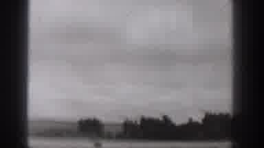 Washington USA (1938): People Speeding In Motorboat Near Mountain Lake On Cloudy