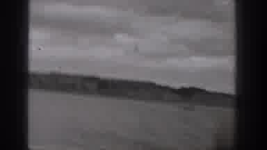 Washington USA (1938): A Person Racing A Boat Across A Body Of Water On A Cloudy
