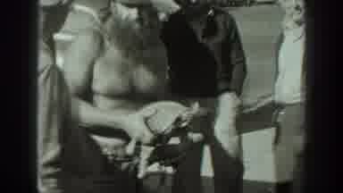 California USA (1939): A Person Holding 2 Turtles On The Side Of The Street