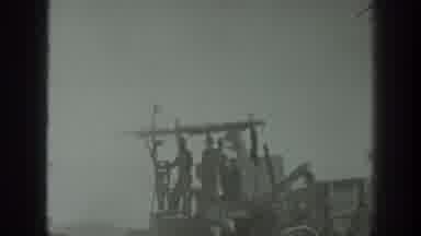 California USA (1939): A Man Operates A Tractor As Two Others Stand On The Machine