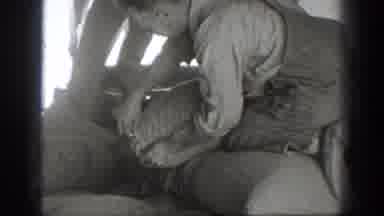California USA (1939): Workers Cutting Open A Big Bag Of Rice And A Train Moving