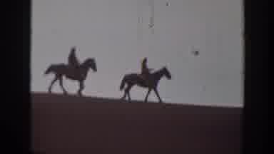 Montana USA (1939): A Couple Riding Horses Down What Looks Like A Sand Dune
