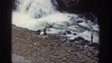 Wyoming USA (1939): People Walking By A Waterfall's Edge Near The Forest