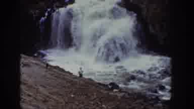 Wyoming USA (1939): Two People Stand Next To A Waterfall And A River