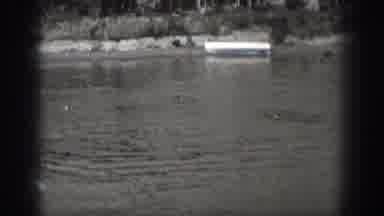Washington USA (1940): Two Men Cruising In A Small Motor Boat Causing A Wake In