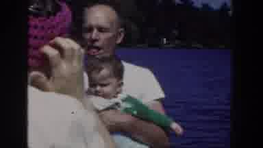 Wisconsin USA (1953): Smoking Man Holds Fussing Baby On Boat