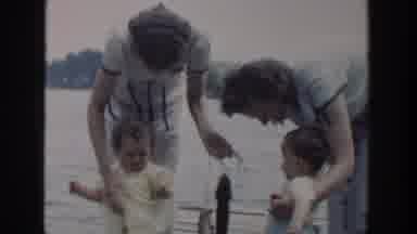 Wisconsin USA (1953): Two Ladies With Two Kids Playing With Fishes At The Seashore