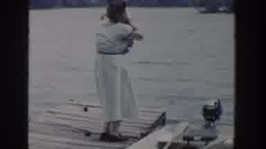 Wisconsin USA (1953): A Woman Picks Up A Baby Out Of A Small Pleasure Boat