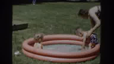 Wisconsin USA (1953): Woman And Two Toddlers Play In Kiddie Pool In Yard