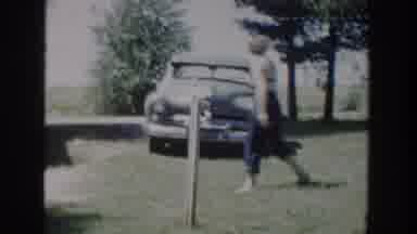 Wisconsin USA (1953): A Woman Walks By A Car As Kids Play In Water Pools