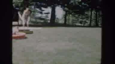 Wisconsin USA (1953): A Woman Stands By A Child In A Kiddie Pool While Another