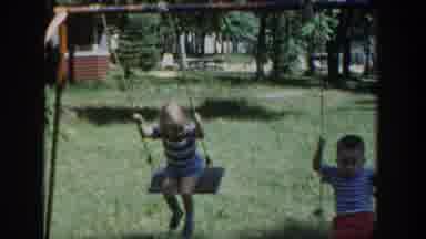 Wisconsin USA (1953): Two Kids Playing In The Swing At The Grass Park