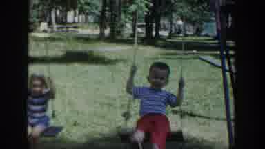 Wisconsin USA (1953): Young Children Playing On Swing Set With Grandfather