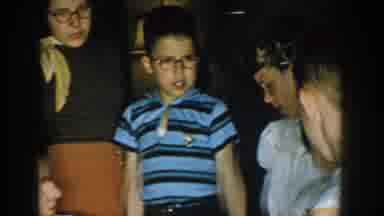 Michigan USA (1957): Children Gathering Around To Look At Woman Wearing Glasses