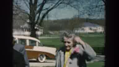 Michigan USA (1957): People Dressed In Formal Wear Gather In Front Of Cars On A