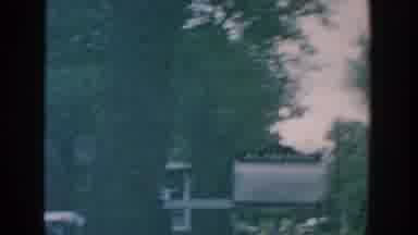Wisconsin USA (1957): Woman Wearing Grey Dress Glasses Walks Towards House Steps