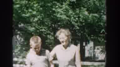 WISCONSIN USA-1957: Boy and Woman Walking Through Trees and Grass Near Lake