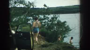 Wisconsin USA (1957): Woman In Blue Swimsuit Runs To Water And Wades In