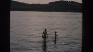 Wisconsin USA (1957): A Boy And Man Walk Out Into A Lake As Others Are Swimming