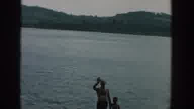 Wisconsin USA (1957): A Man And Three Kids Are Playing At The Middle Of The Sea