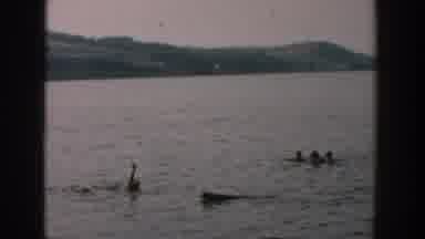 Wisconsin USA (1957): Older Man Playing In Lake Moving His Hand To Attract