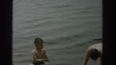 Wisconsin USA (1957): Adult Man And A Boy On The Edge Of A Lake With Calm Water