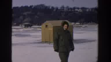 Wisconsin USA (1957): A Person Wearing Heavy Winter Clothes Fishing Through A Hole